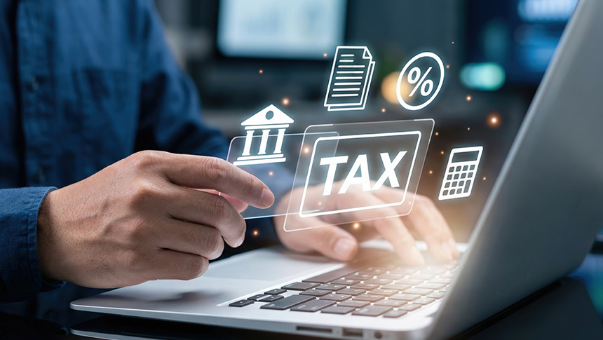 A man using a laptop to manage business tax obligations.