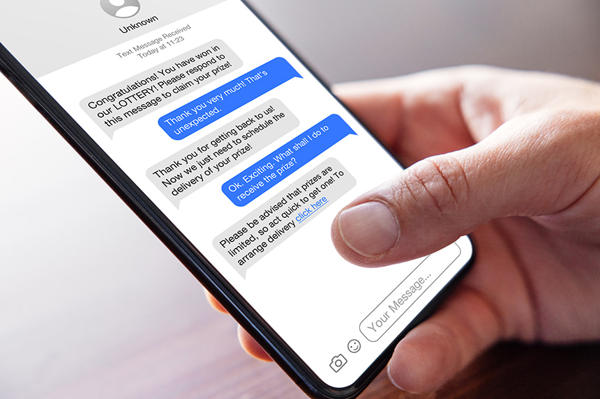 Photo of a smartphone with scam text messages and a suspicious link.