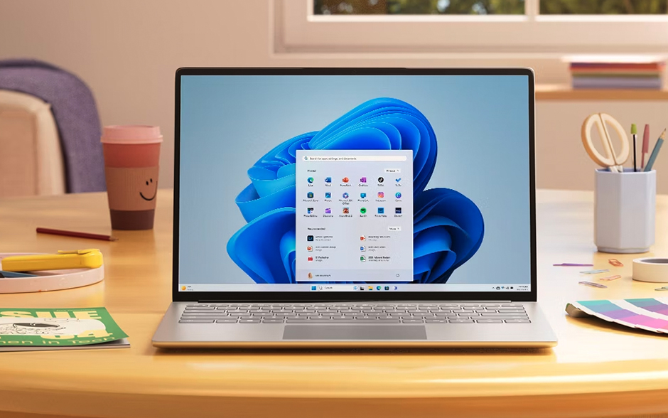 A laptop on a desk showing Microsoft 11 OS.