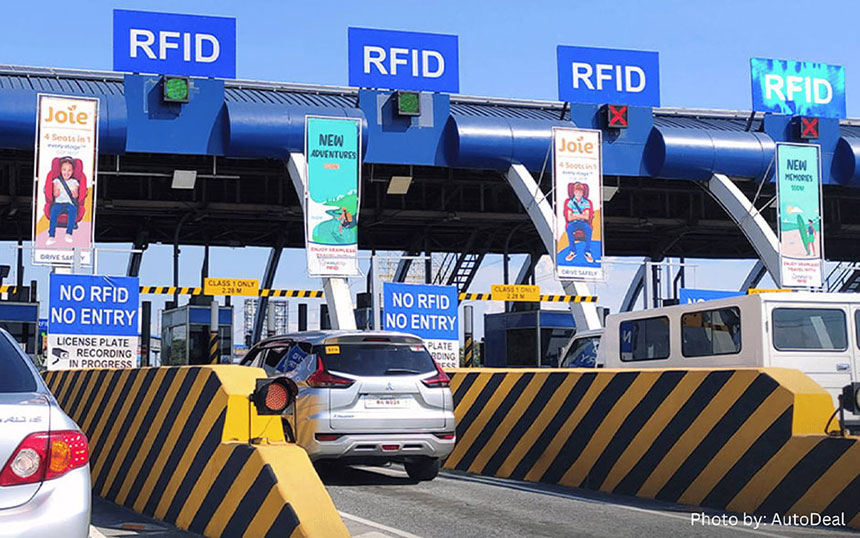 Vehicles passing through RFID toll gates with prominent âNO RFID NO ENTRYâ signs, emphasizing electronic toll collection systems. Photo by AutoDeal.