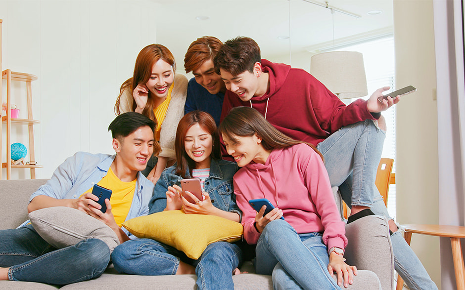 A group of young friends enjoying a fun moment together while looking at their smartphones