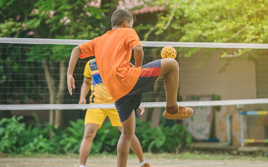 A vibrant capture of a classic Pinoy game, âSipaâ (or Sepak Takraw), showcasing two players skillfully volleying a rattan ball across the net with precision and agility, set in a lively outdoor setting.