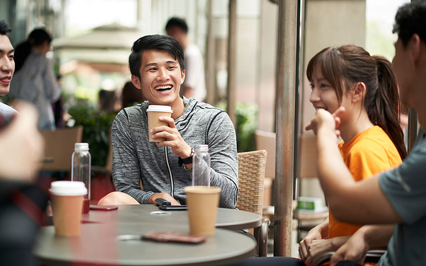 A group of friends enjoying refreshments at an outdoor coffee shop, laughing and reminiscing after an engaging game. A perfect way to relax and bond after the adrenaline rush of playing together.