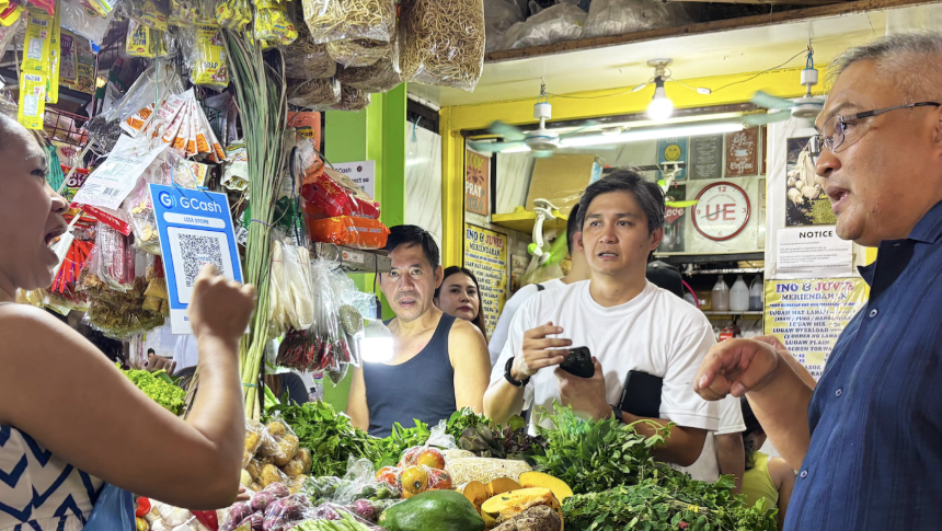 Globe President and CEO Carl Cruz speaks with a vendor at Maypajo Public Market.