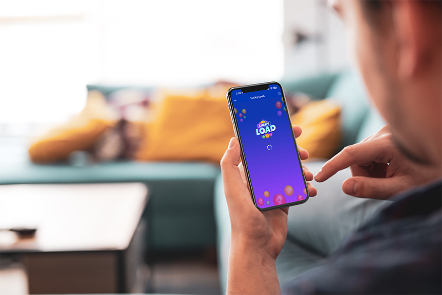 Man smiling while using a smartphone at home.