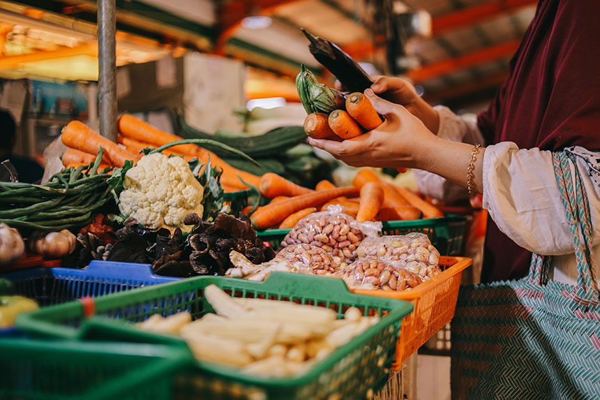 Person selecting fresh vegetables at a local market stall.