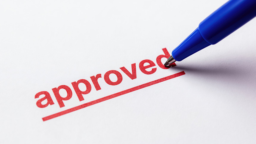 A blue pen underlining the word "approved" printed in red text on white paper.