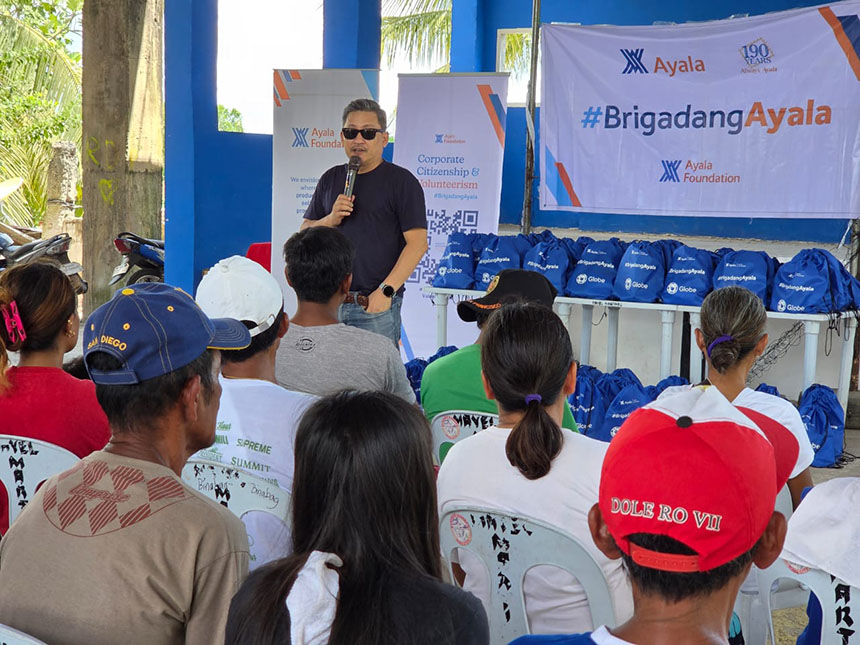 Globe and Ayala representative addresses Cebu residents during the #BrigadangAyala earthquake relief distribution.