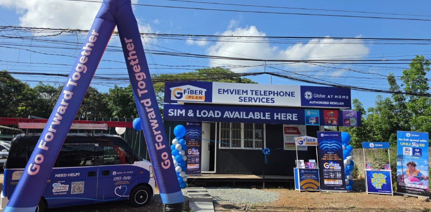 Exterior of the Globe OSDO hub in Angono, Rizal, featuring a blue inflatable dancer, promotional banners, and a service van.