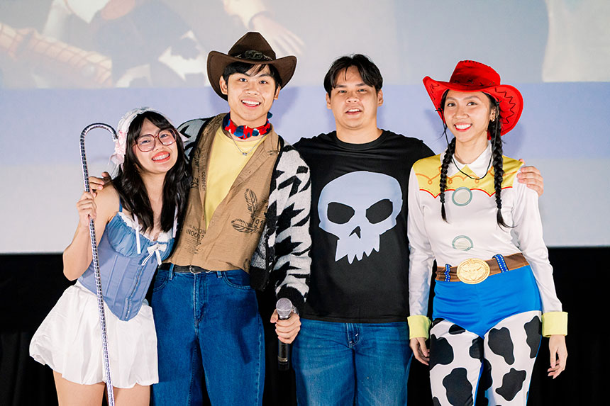 Students smiling and posing while wearing Toy Story-themed costumes.