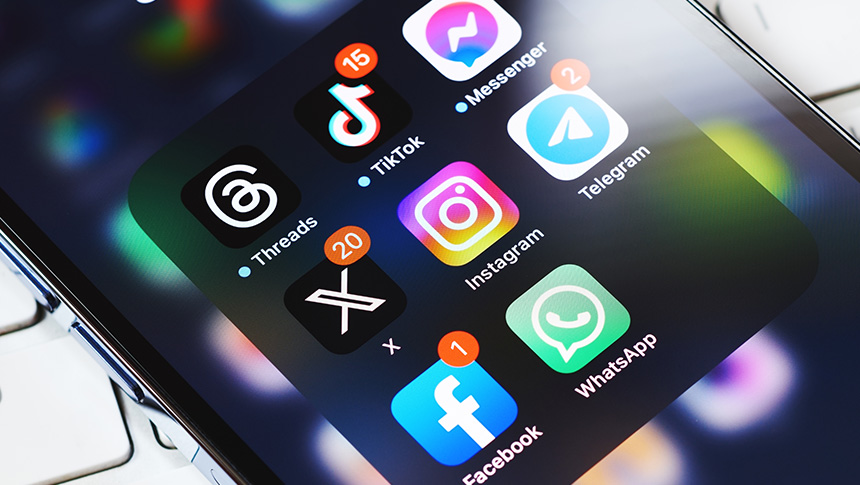 Smartphone screen displaying social media app icons including Threads, TikTok, Messenger, Telegram, Instagram, X, Facebook, and WhatsApp.