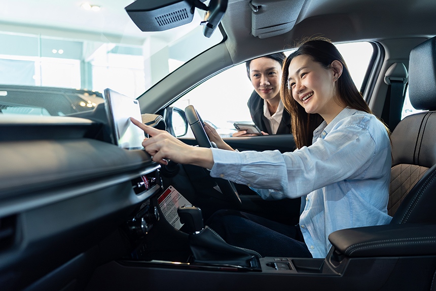 Person exploring a car's touchscreen display while learning about vehicle features.