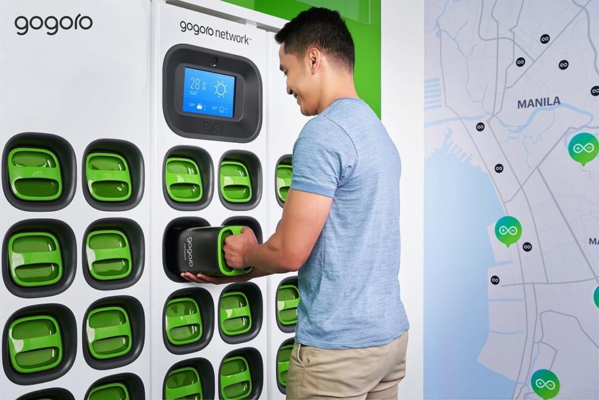Young Filipino man pulls out a Gogoro battery in a Gogoro swapping station.
