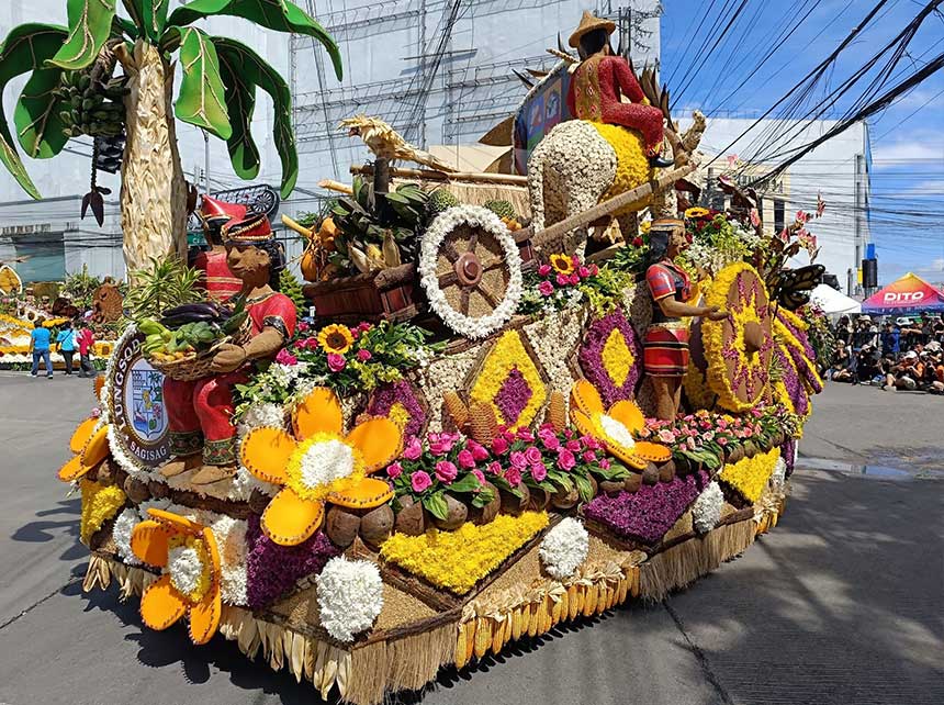 Floral float covered in fresh blooms, fruits, and farmer figures at the Pamulak sa Kadayawan parade in Davao