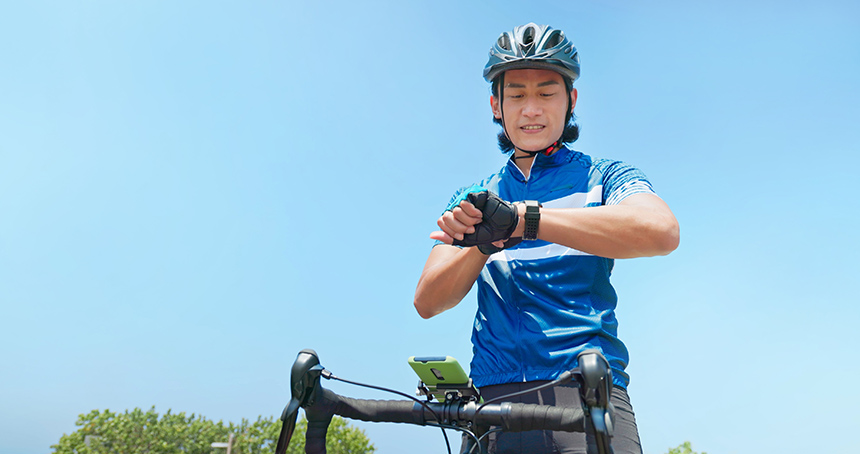 Person checking a smartwatch while taking a break from biking.