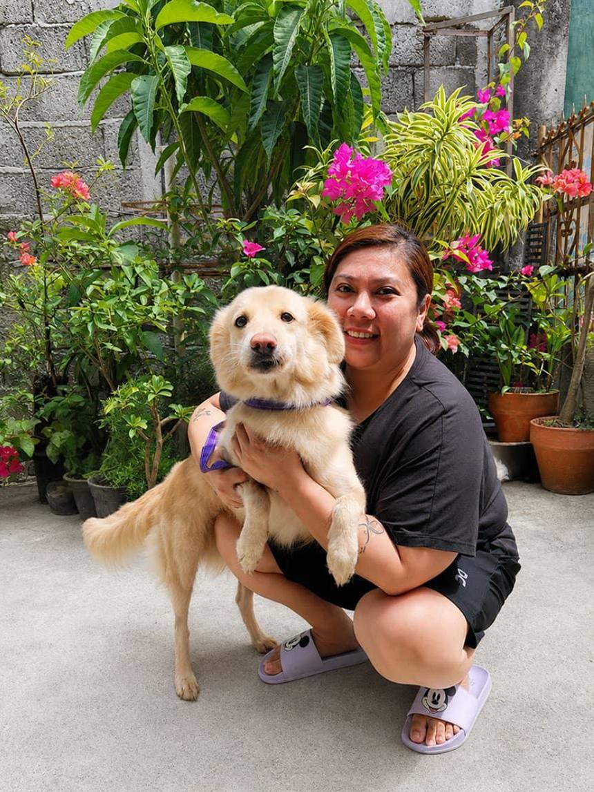 Juni with her Aspin, Hermione Ginger, in their garden at home.