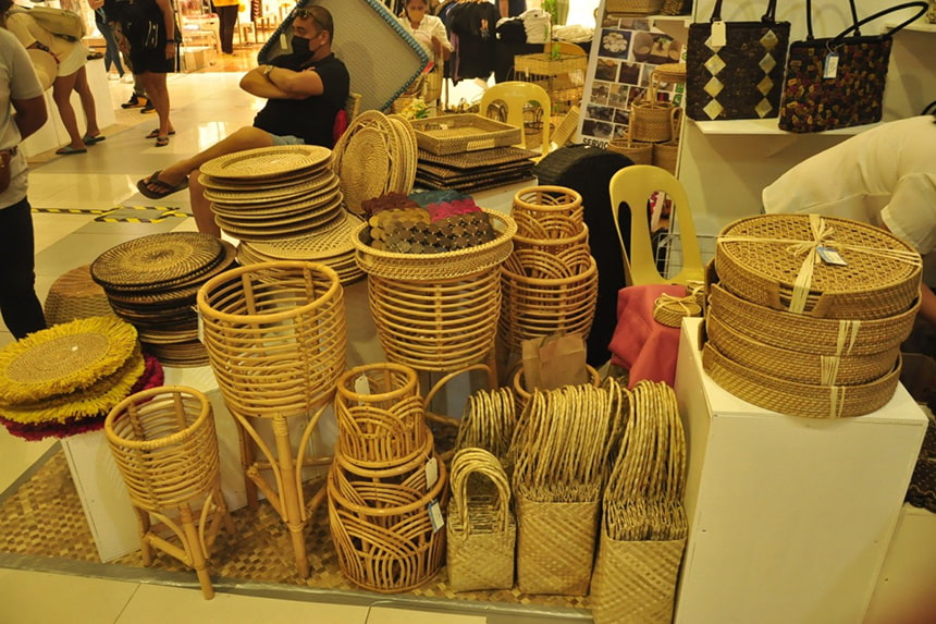 Woven baskets, books, and dÃ©cor in a stall at the Sandugo Trade Expo.