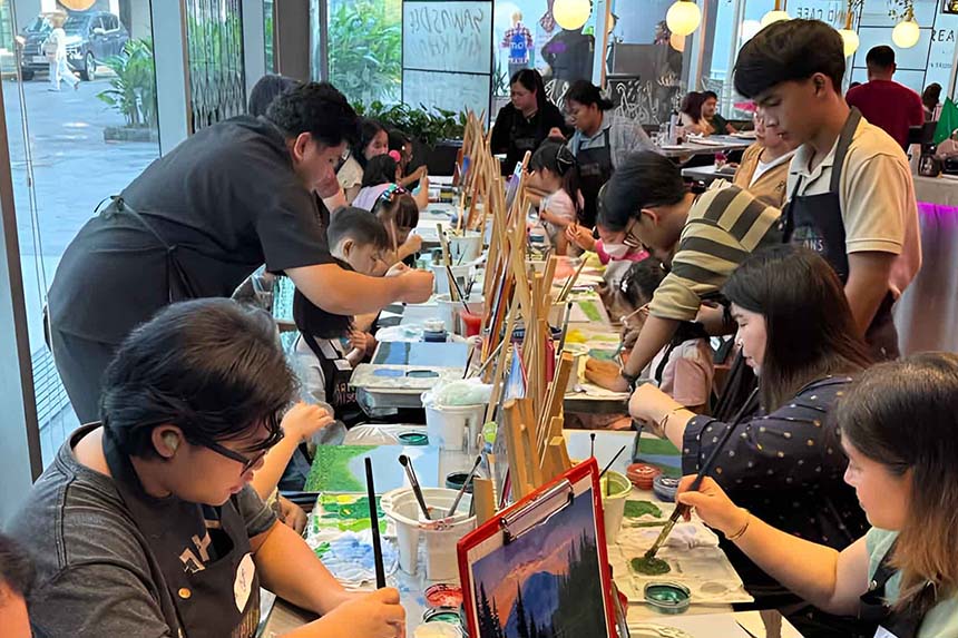 A group of people enjoying a painting session, surrounded by art supplies and colorful canvases.