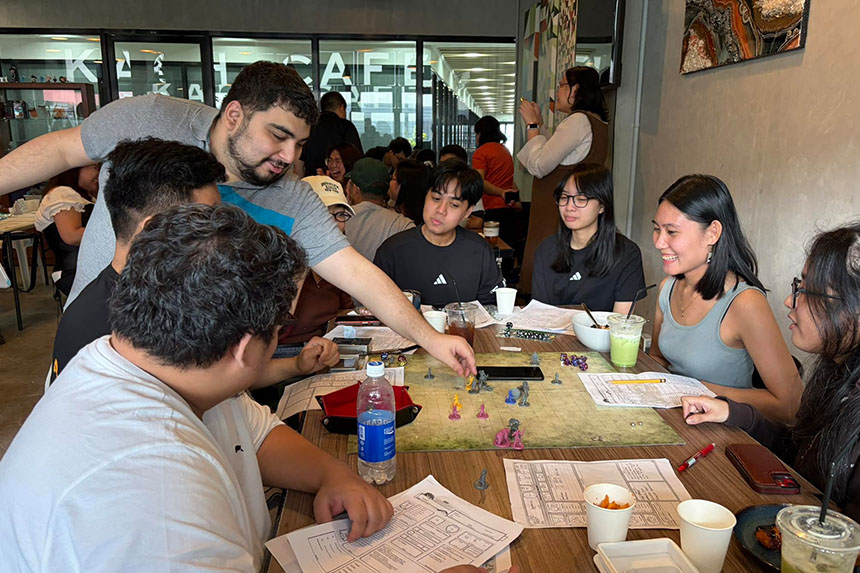 A group of friends gathered around a table, enjoying a lively board game together.