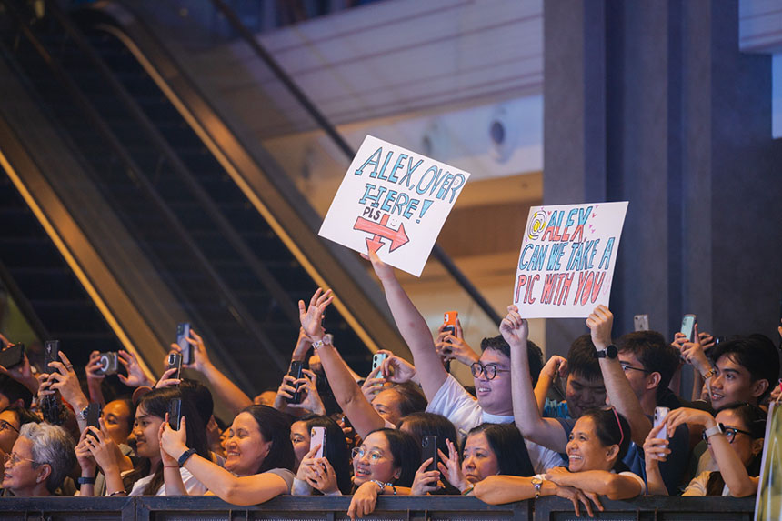 Fans hold up signs and smartphones in the crowd during Alex Ealaâs homecoming event in Manila.