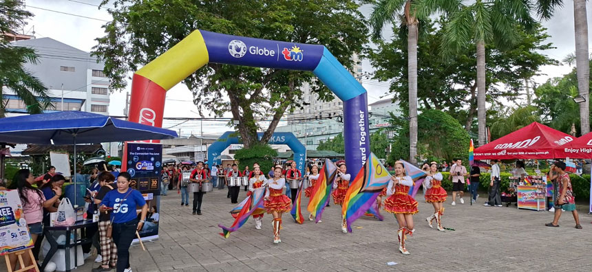 Pride flags passing under a Globe event arch at the Cebu Grand Pride Parade 2026 held in Plaza Independencia.