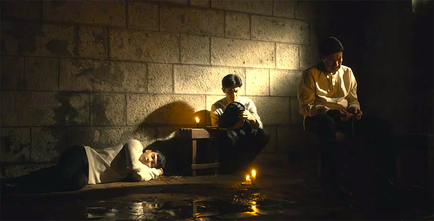 Fathers Gomez, Burgos, and Zamora inside a dimly lit prison cell in GomBurZa.