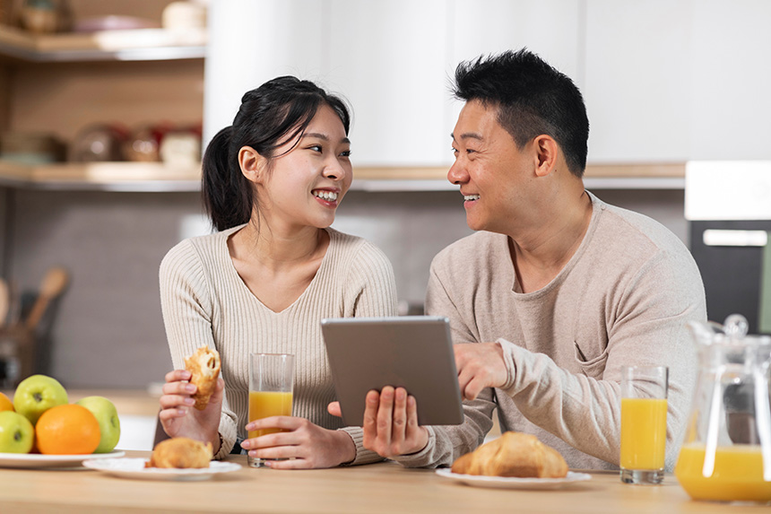 Two people checking nutrition information on a tablet at the table.