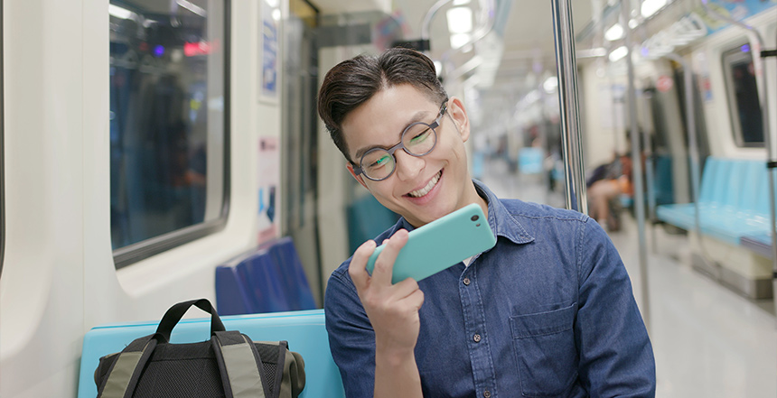 Man checking his phone while riding a train