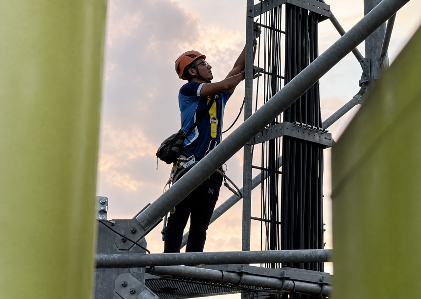 Globe Telecom technician working on a telecommunications tower in the Philippines to expand mobile data connectivity.