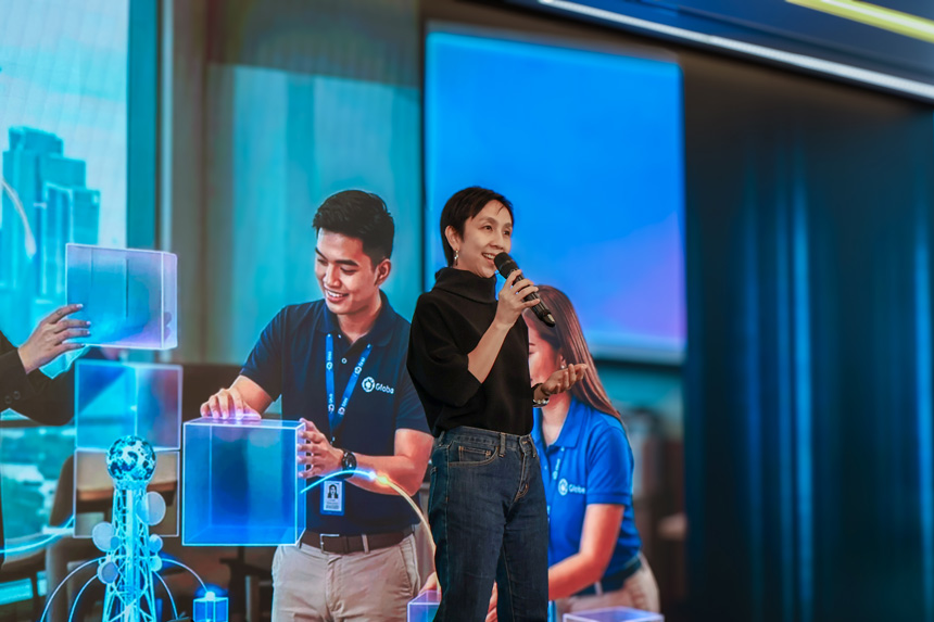 Globe's Chief Marketing Officer KD Dizon delivering a speech at the Globe Pathfinder Program kickoff event alongside a digital technology display.