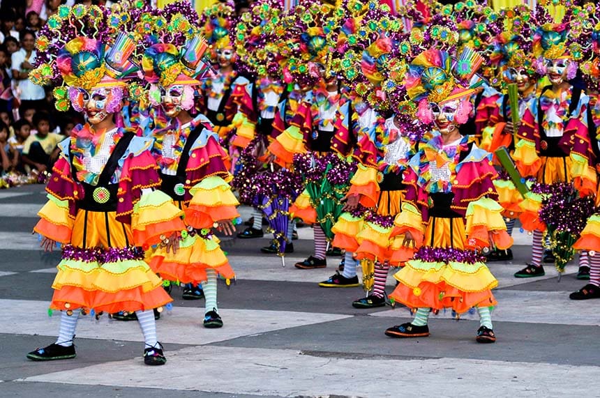 MassKara Festival dancers in colorful costumes and smiling masks performing in Bacolod City.