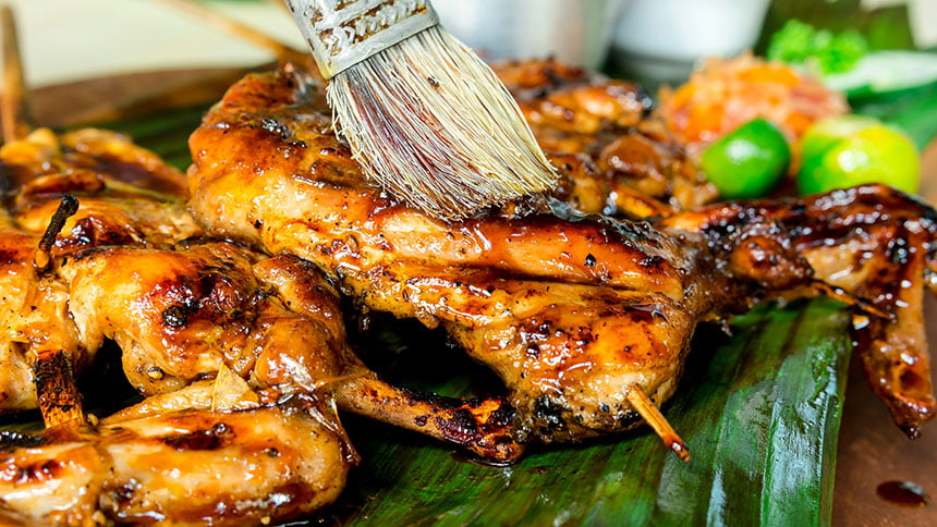 Close-up of chicken inasal with sauce.
