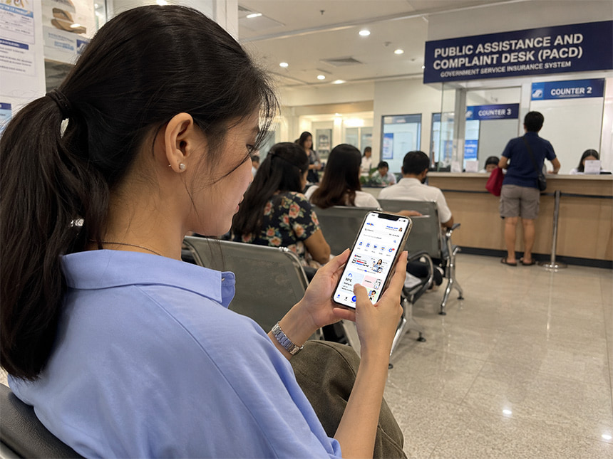 Woman checking her phone while waiting at a government assistance center