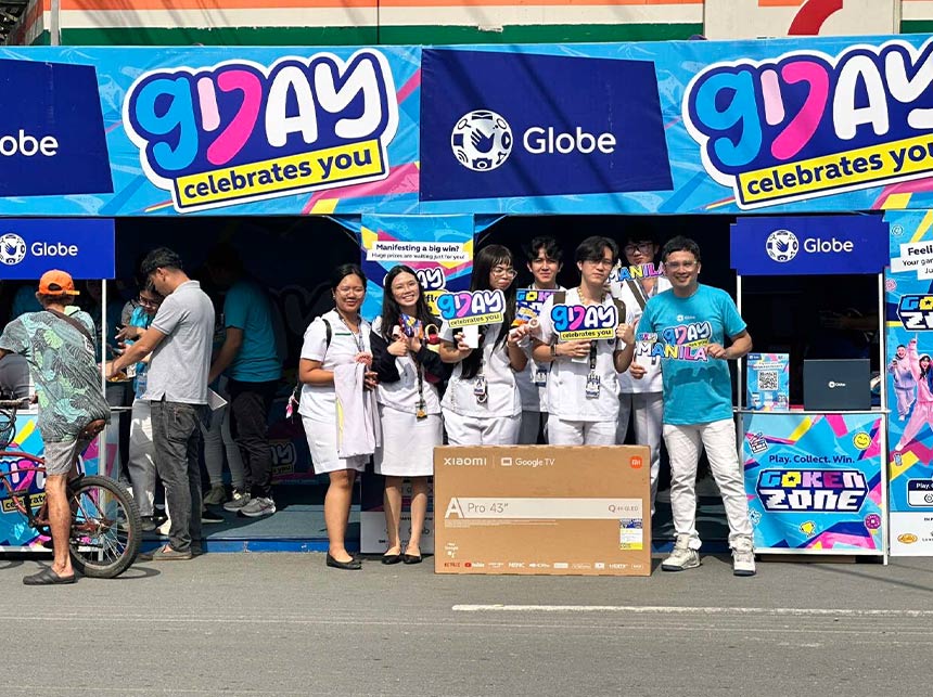 GDay Pop-Up participants posing with a large prize box and GDay event banners.