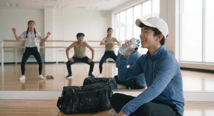 Man taking a break with a drink during a group workout.
