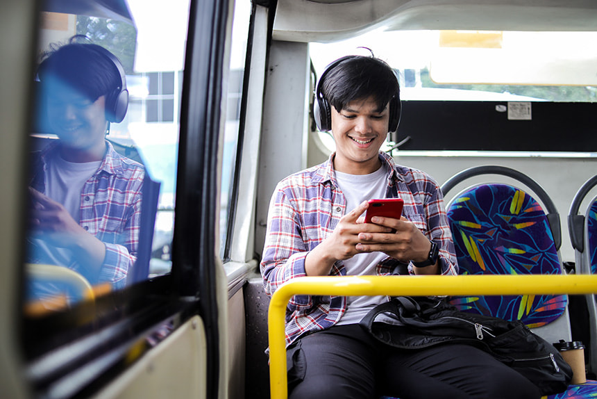 Man using his smartphone while riding public transportation.