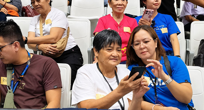 Globe volunteers guide senior citizens in using smartphones during the Senior Digizen program.