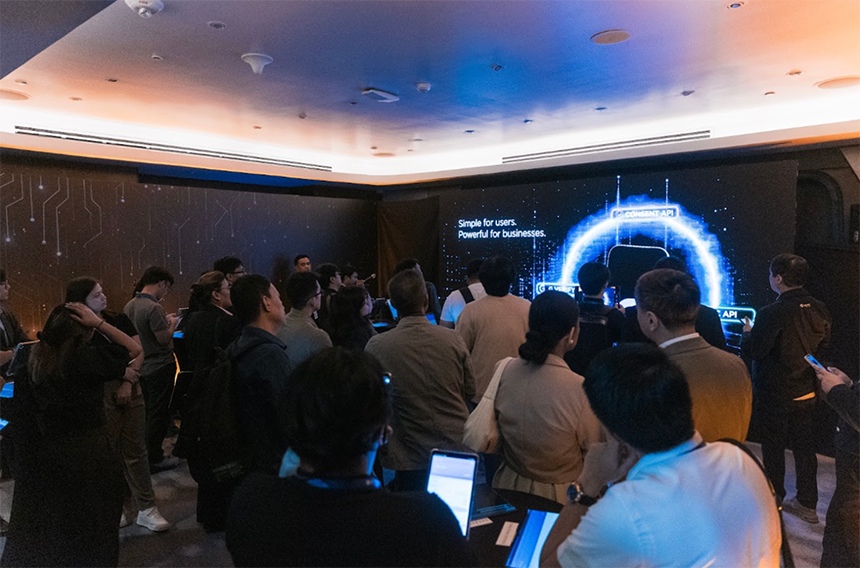 Business leaders watch API Hub demonstration on digital display in Experience Room.