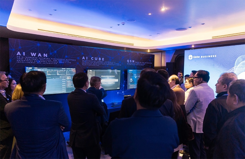 Executives watch AI WAN and network stress test demonstration in Orchestrated Infrastructure room.