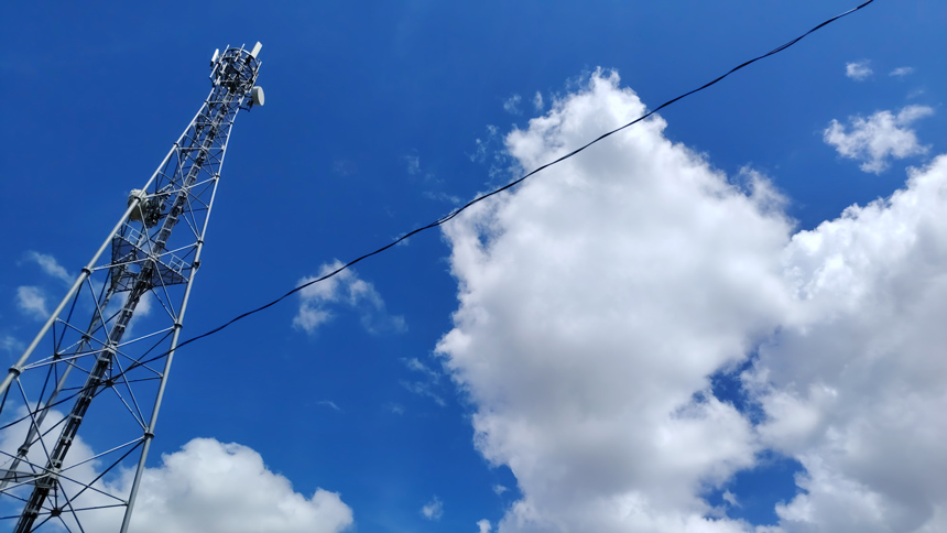 Globe cell tower under a partly cloudy sky supporting sustainable telecom infrastructure.