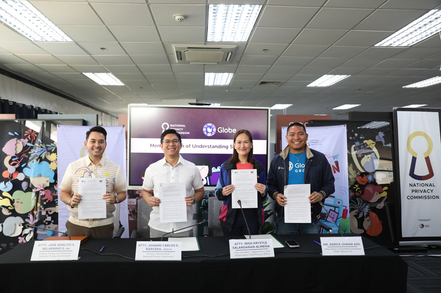 Globe and NPC officials hold signed MOU documents during their partnership renewal for online safety and privacy.