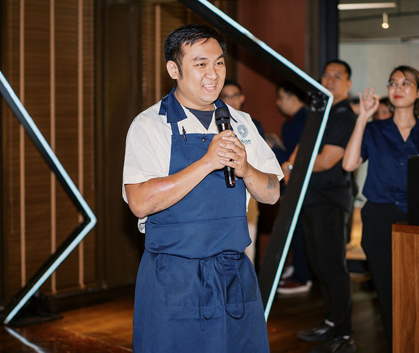 Chef in a blue apron speaks during the Globe Platinum iPhone 18 midnight launch event.